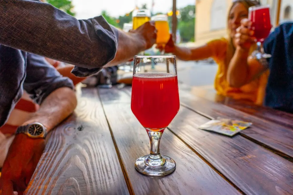 Sour beer on table with friends cheering beers together at a brewery in Johnson City TN