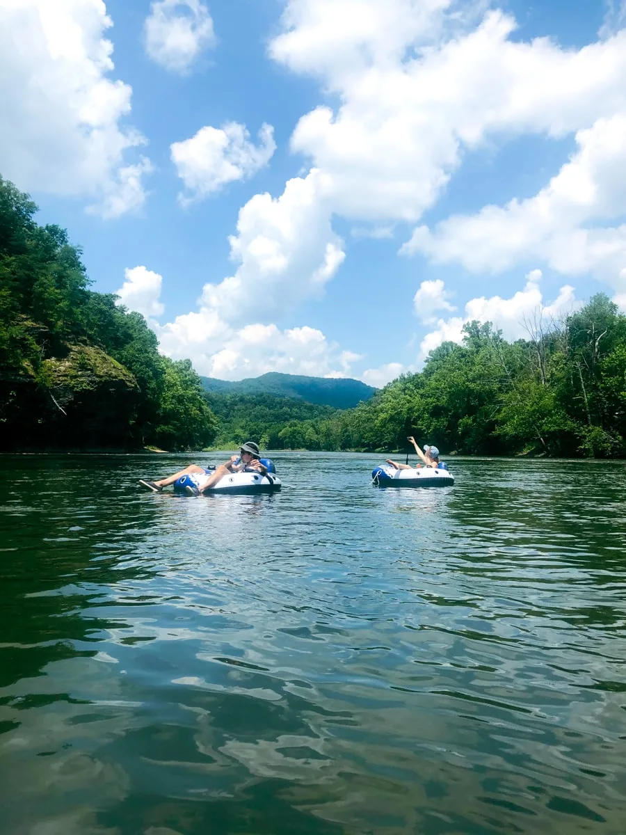 people tubing down the nolichucky river with the mountains in the background near johnson city tn 