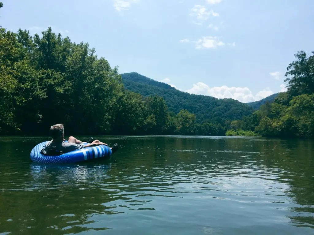 man floating on tube down the Nolichucky River in East TN