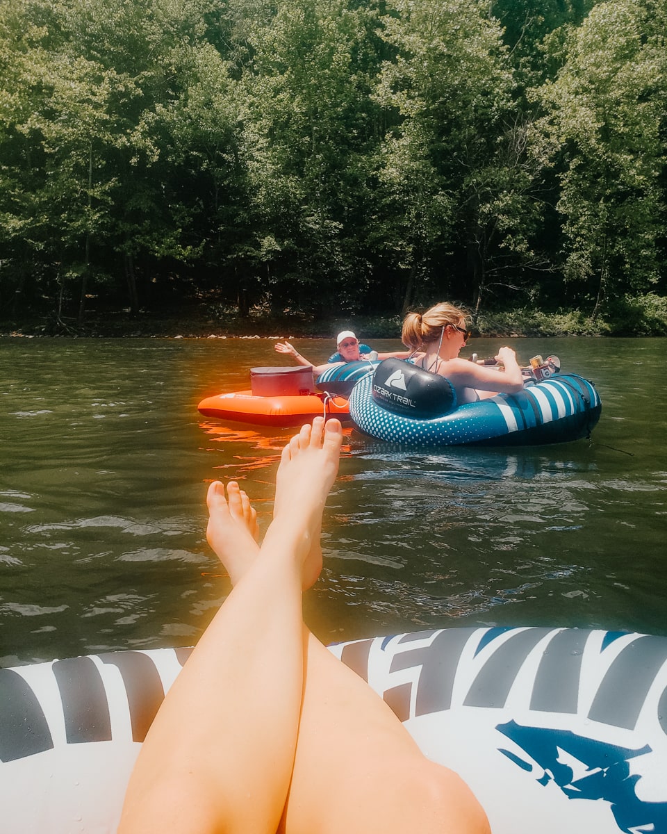Group floating down the Nolichucky river in inflatable tubes