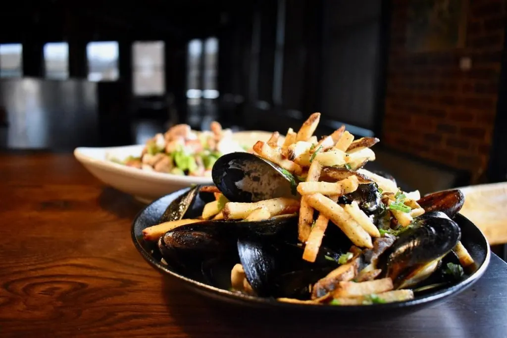bowl of mussels and fries on table