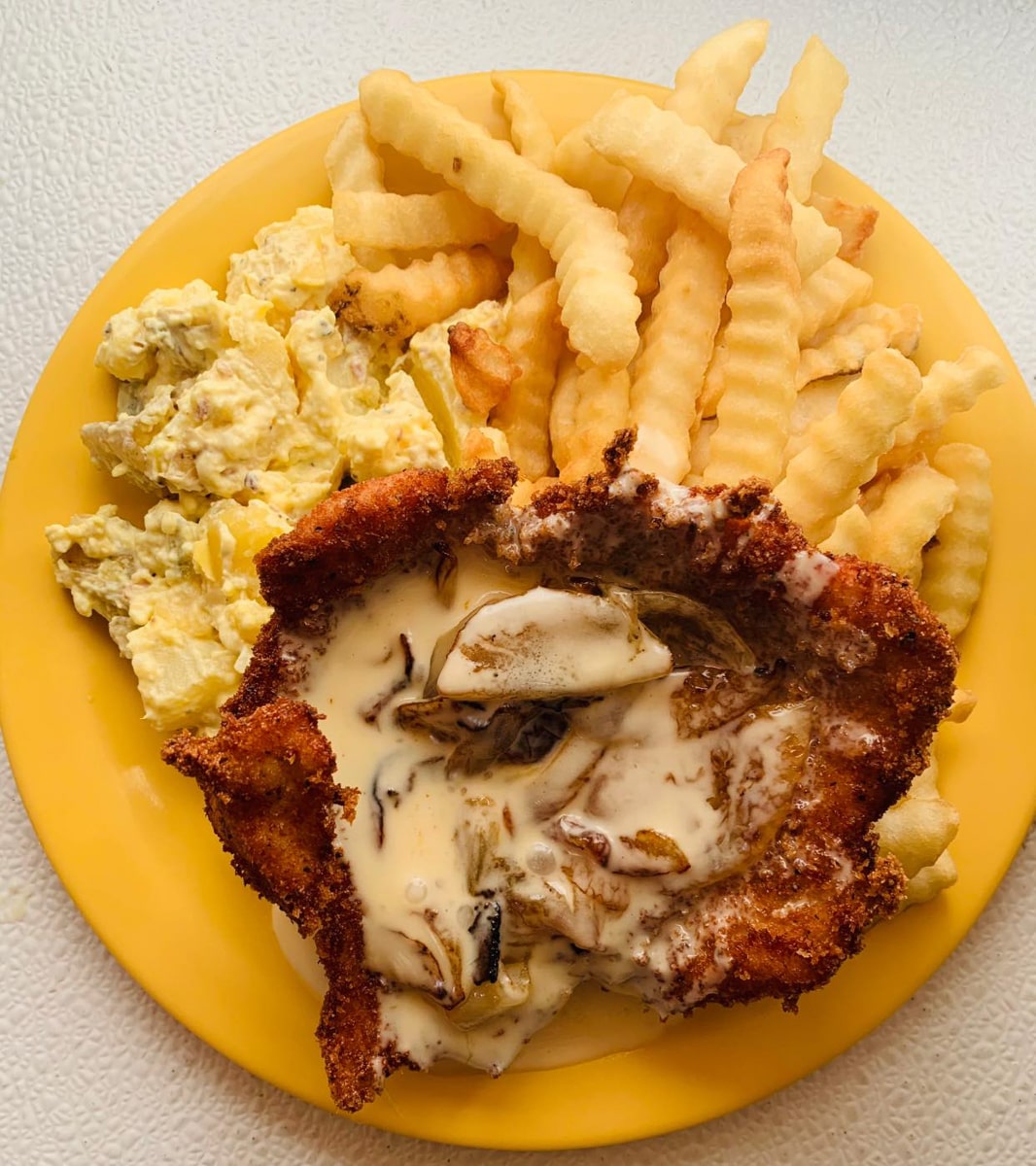 Yellow plate of pork schnitzel and fries