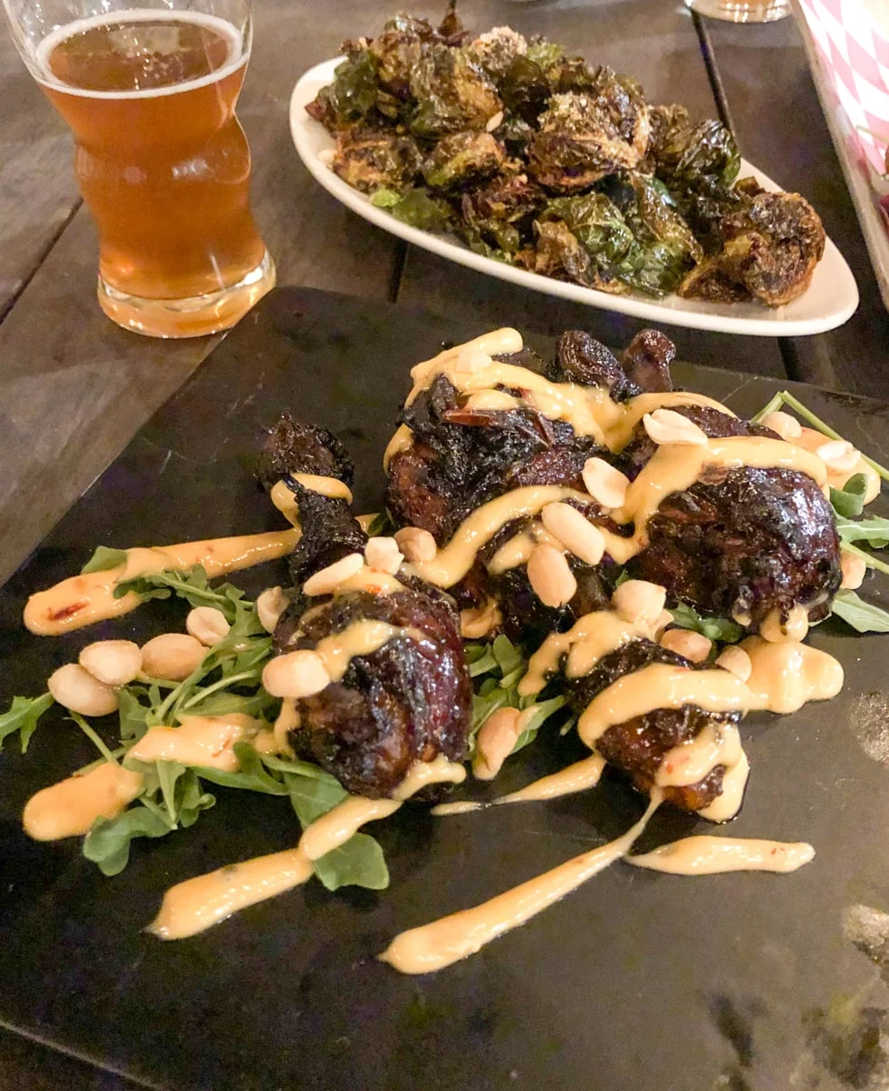 Sticky Chicken Wings with brussel sprouts and a beer from Watauga Brewing Company rooftop bar