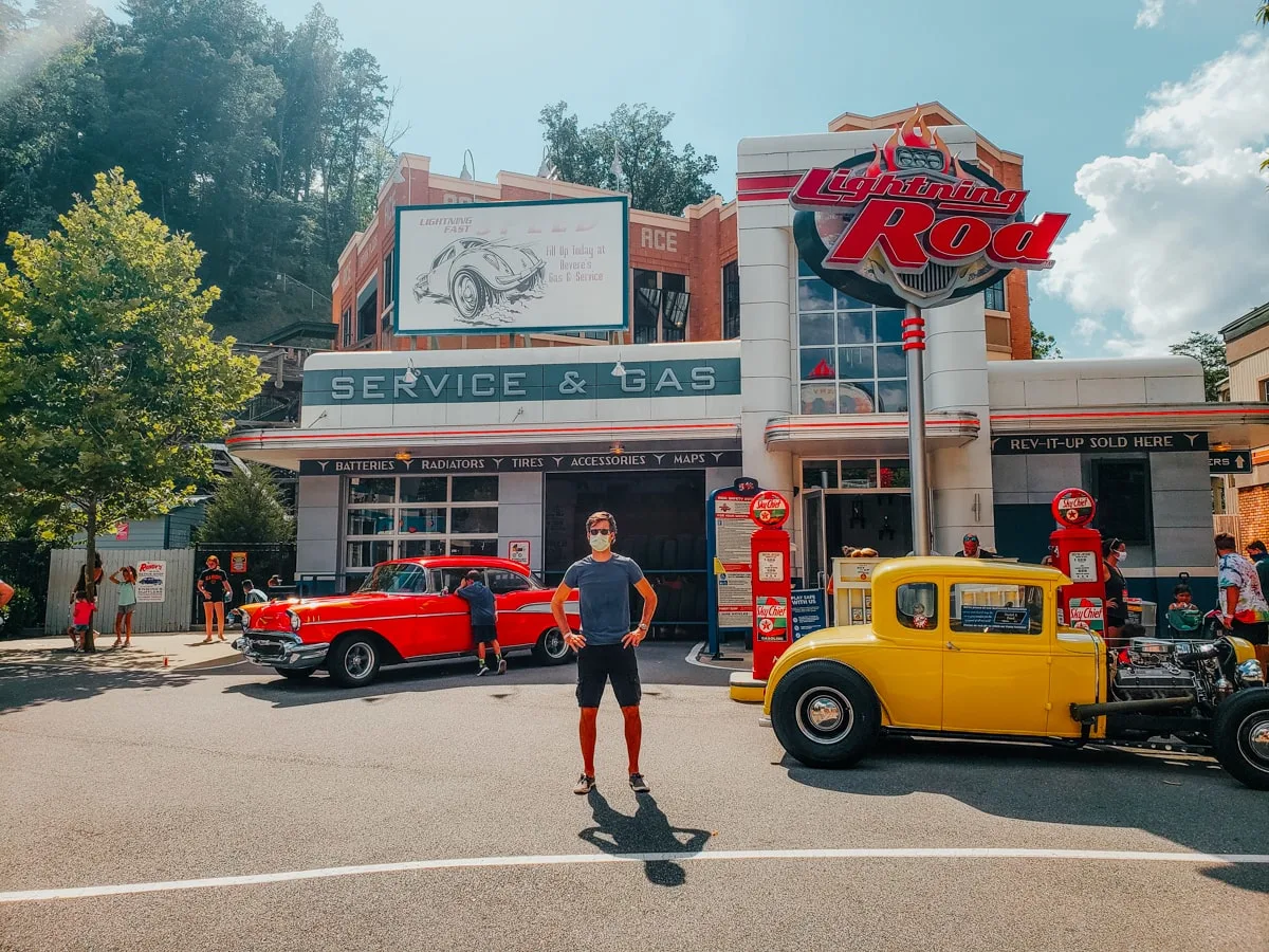 guy standing in front of Lightning Rod ride with vintage cars at Dollywood