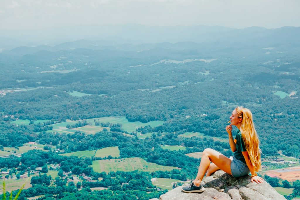 Woman sits on White Rock overlook in Buffalo Mountain Park near Johnson City TN
