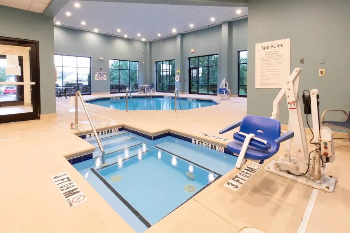 Indoor pool with a hot tub and chair lift at the Holiday Inn Express in Johnson City 