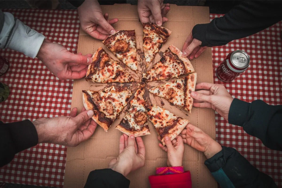 People grabbing slices of pizza from Opie's Pizza Wagon in Johnson City 