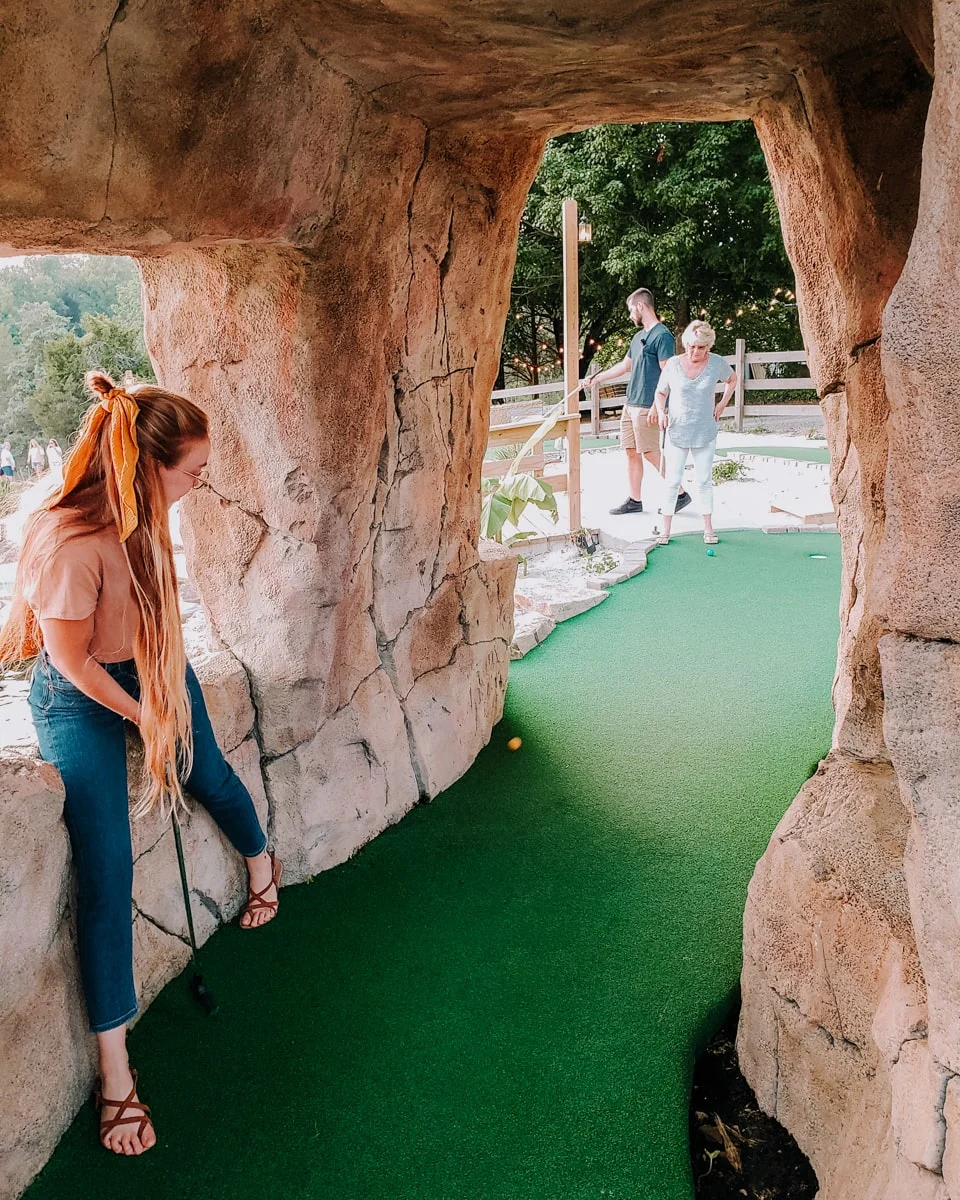 girl playing putt putt mini golf