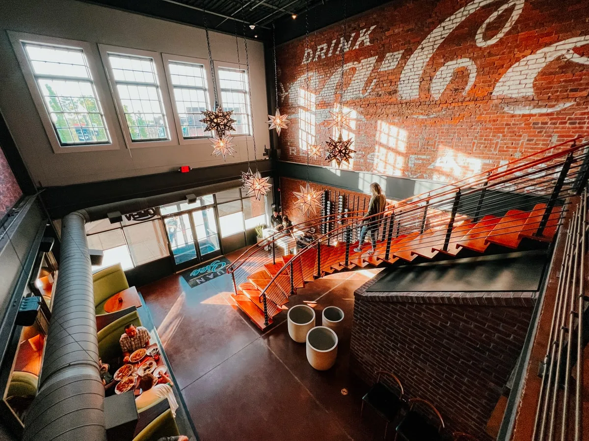Inside the Juan Siao restaurant with high ceilings and an exposed exterior brick wall with coca-cola sign in downtown johnson city 