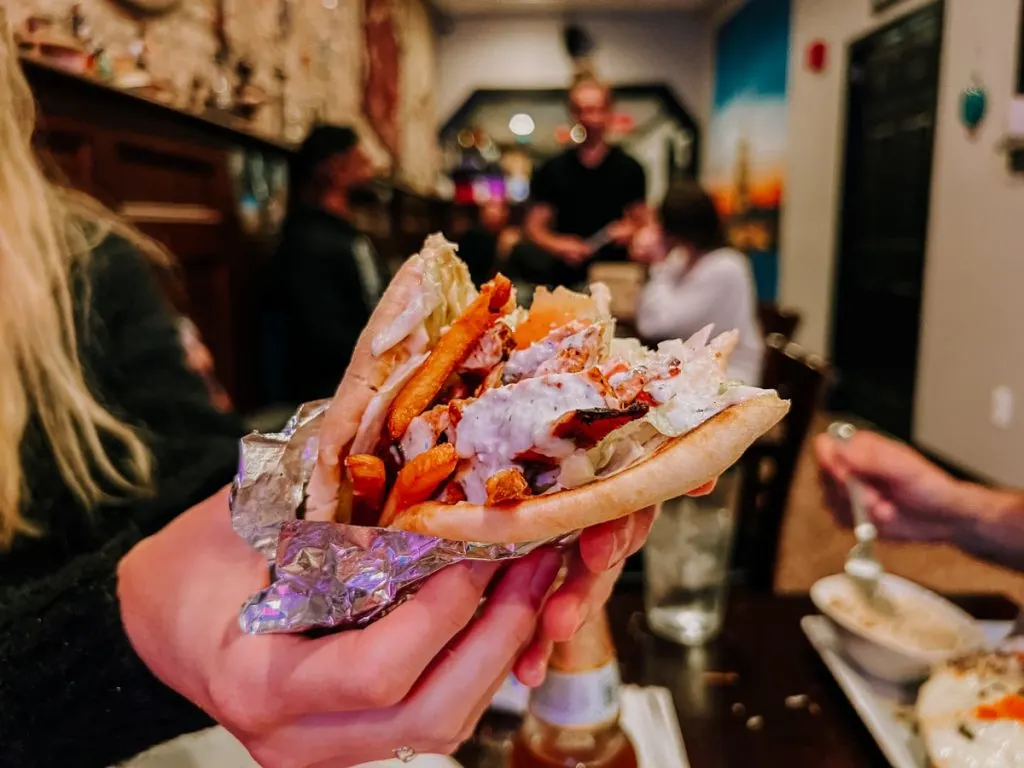 Woman holding a chicken gyro at Red Meze restaurant in downtown Johnson City, TN.