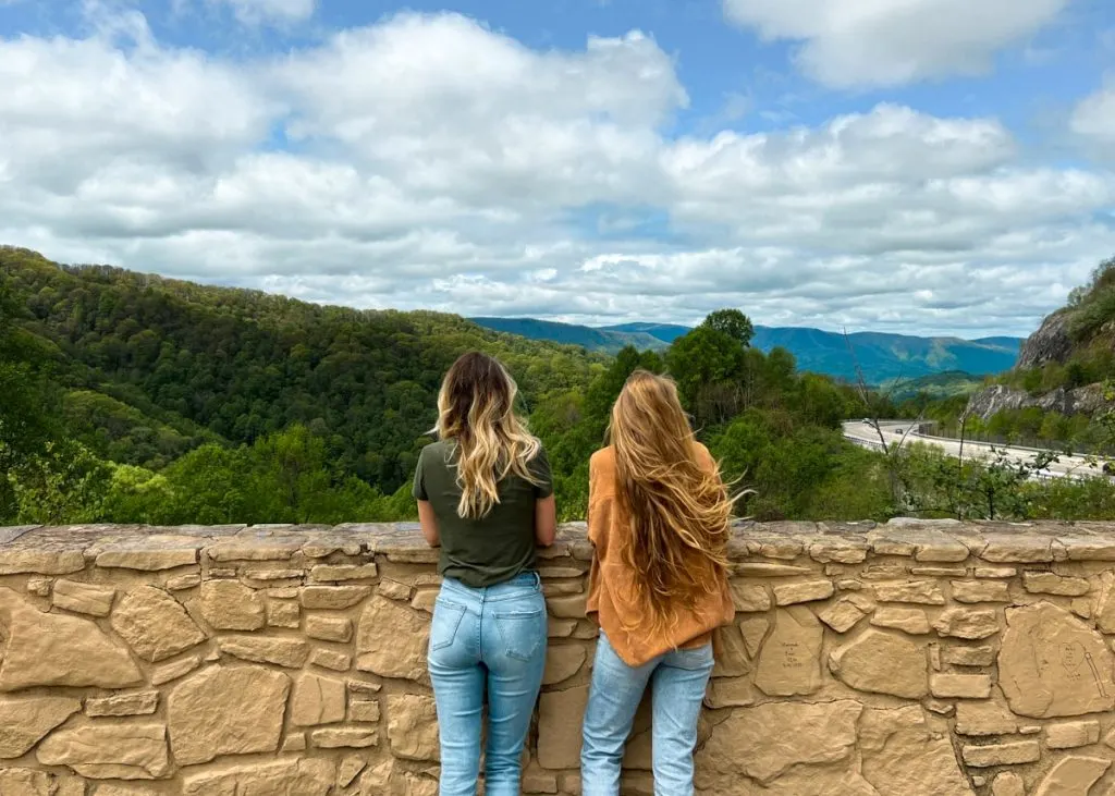 Two women at Sams Gap Overlook rest stop with Blue Ridge Mountains in the background beside the I-26 highway.