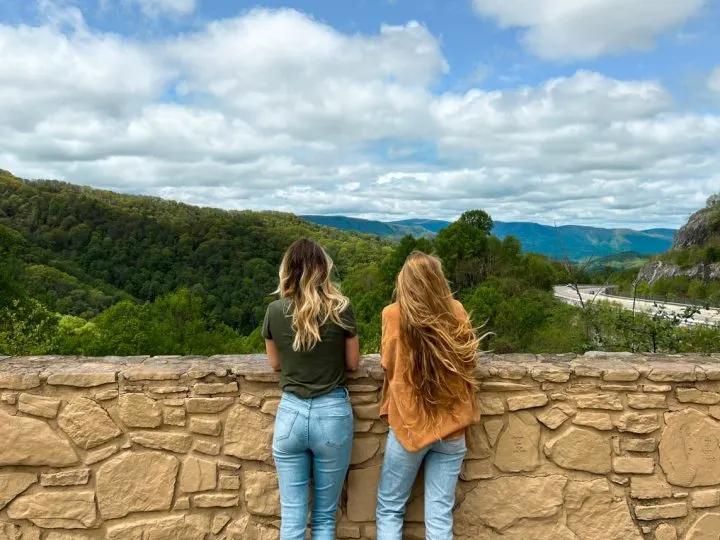 Two women at Sams Gap Overlook rest stop with Blue Ridge Mountains in the background beside the I-26 highway.