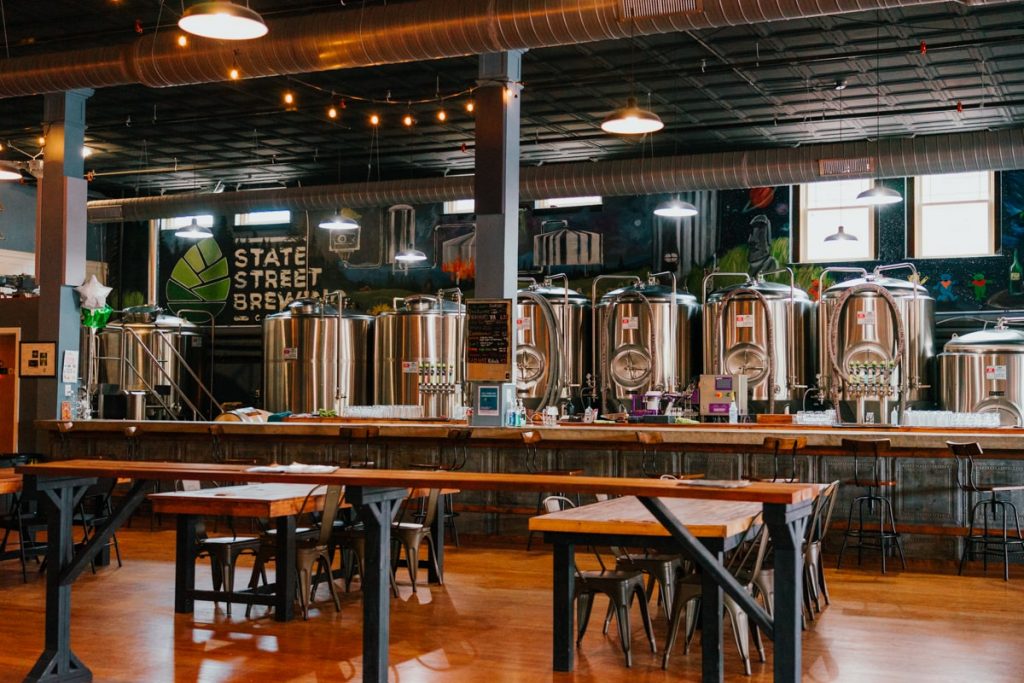 Inside the State Street Brewery in Bristol TN-VA with stainless steel beer barrels and wooden tables.