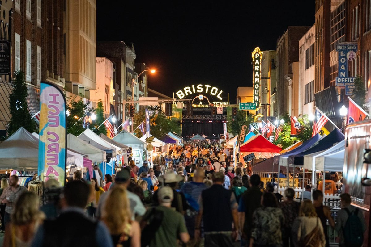People attending the Bristol Rhythm & Roots Reunion Music Festival at night with the Bristol sign in the background