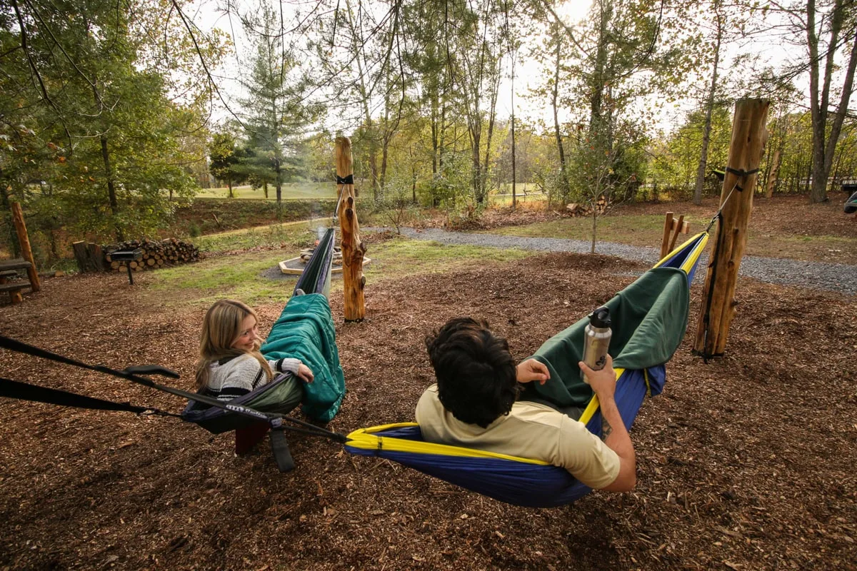 people laying in hammocks at the hammock camping at warriors path state park in kingsport as a fun place to go camping in the tri-cities