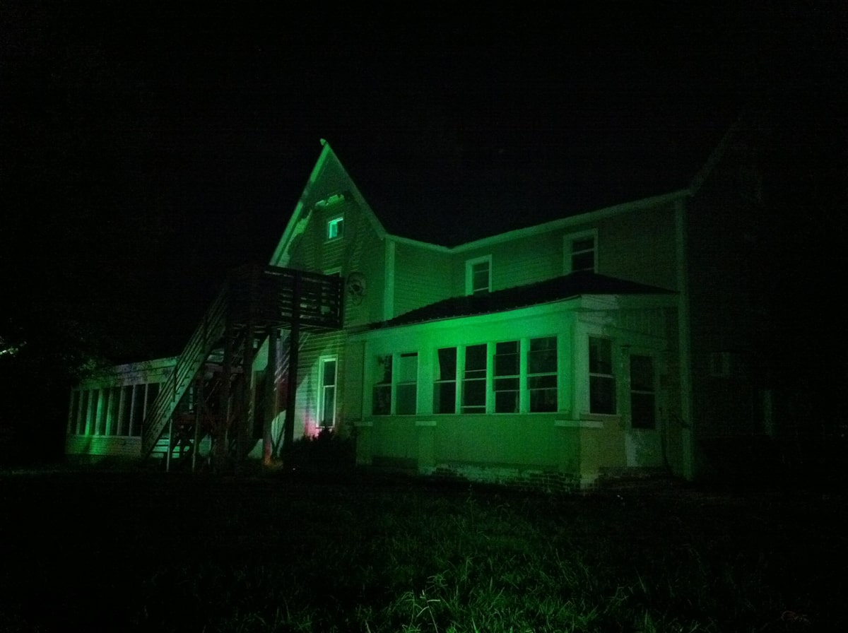 Frightmare Manor house lit up green and looks scary