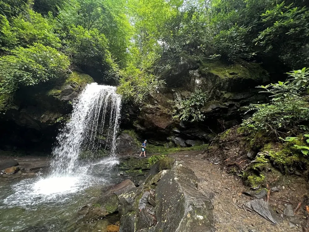 Person walking along trail behind Grotto Falls in the Smoky Mountains 