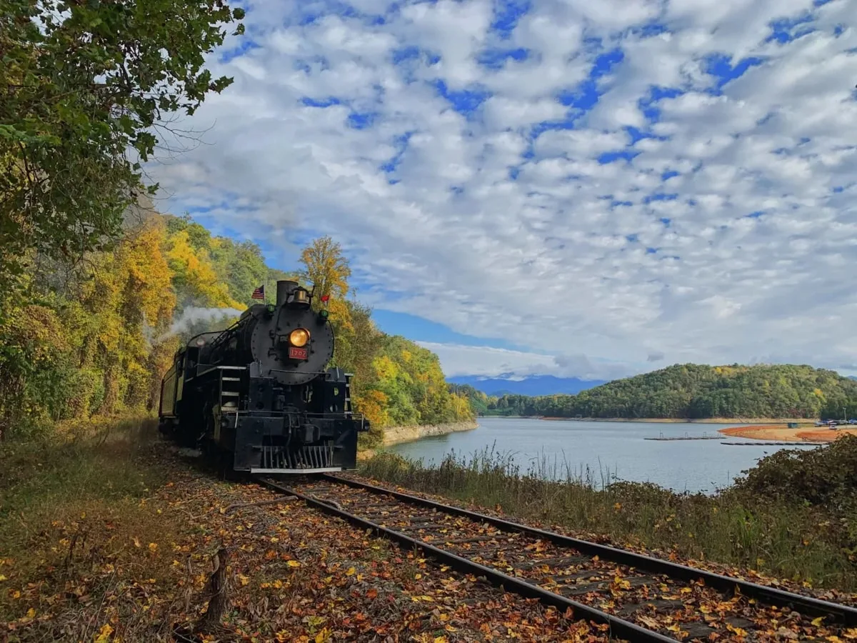 Great Smoky Mountain Railroad in Bryson City TN with blue skies and lake in background