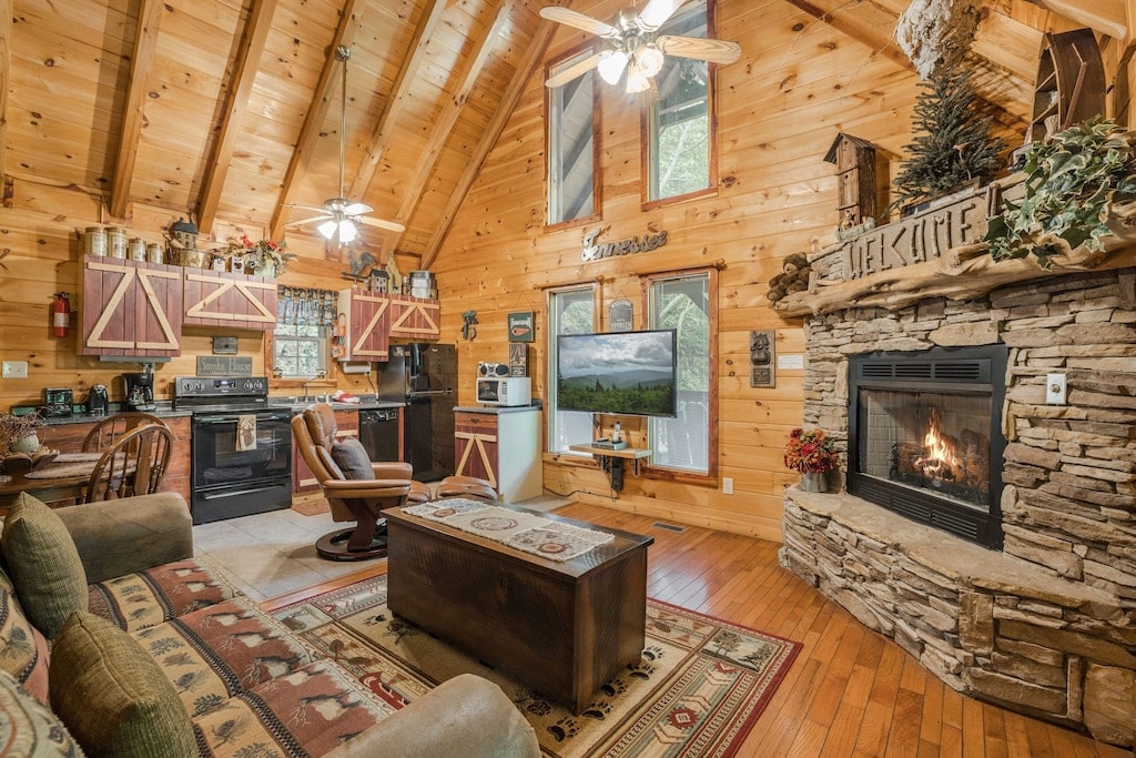 cozy cabin with lit fireplace and an A-frame roof with high ceilings. 