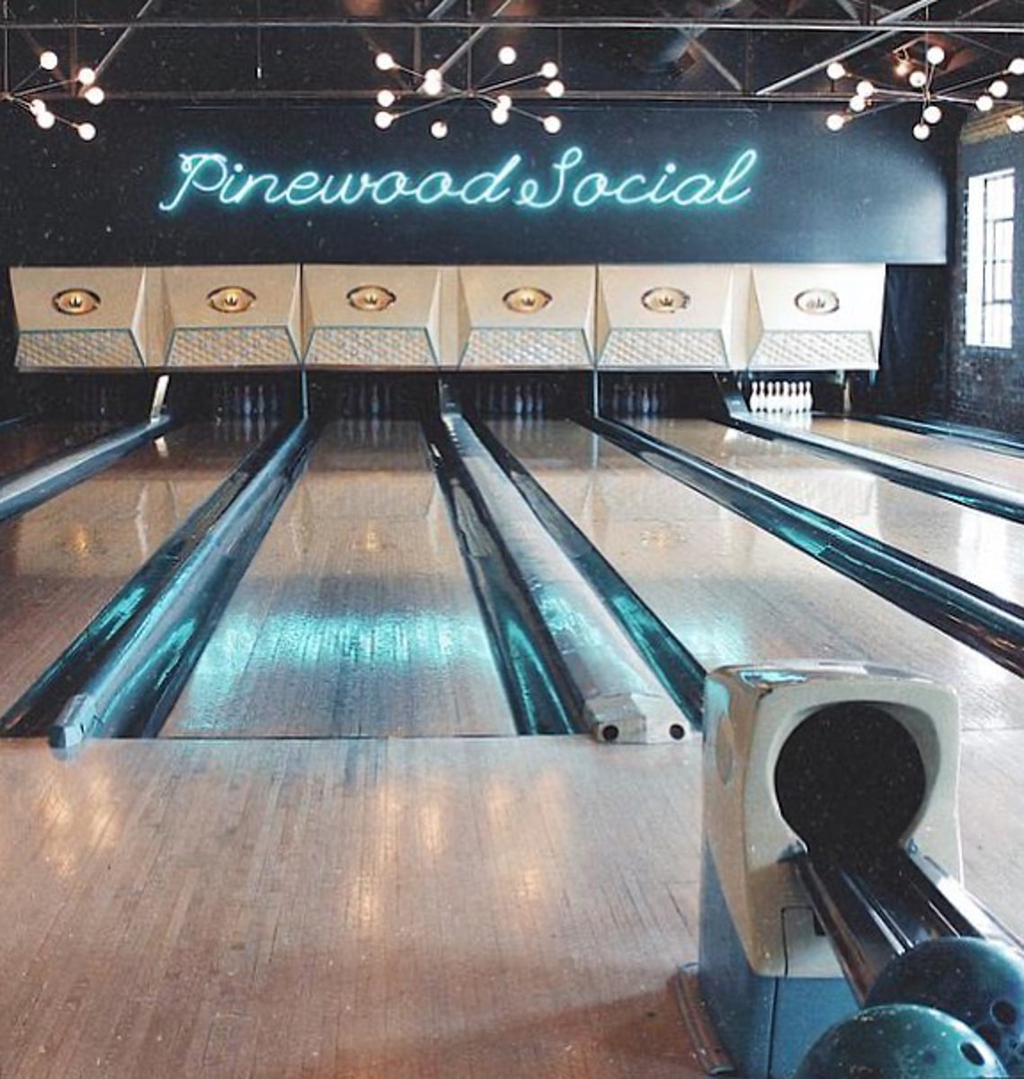 pinewood social bowling lanes with neon sign and wooden floors