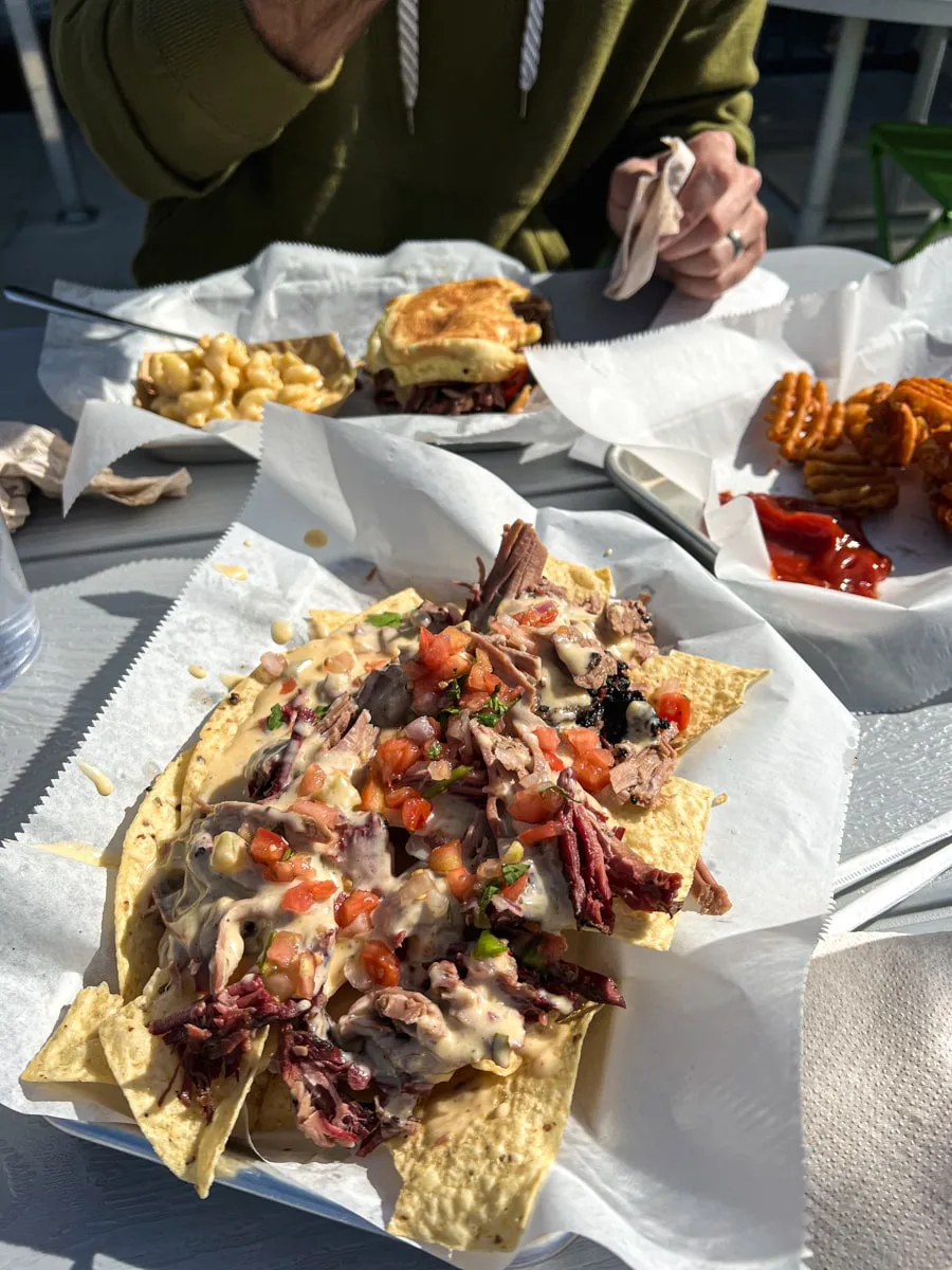 Brisket BBQ Nachos topped with cheese, tomatoes, onion, cilantro, and bbq sauce 