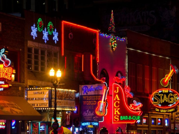 Downtown Nashville in the winter with neon lights illuminating restaurants and street.