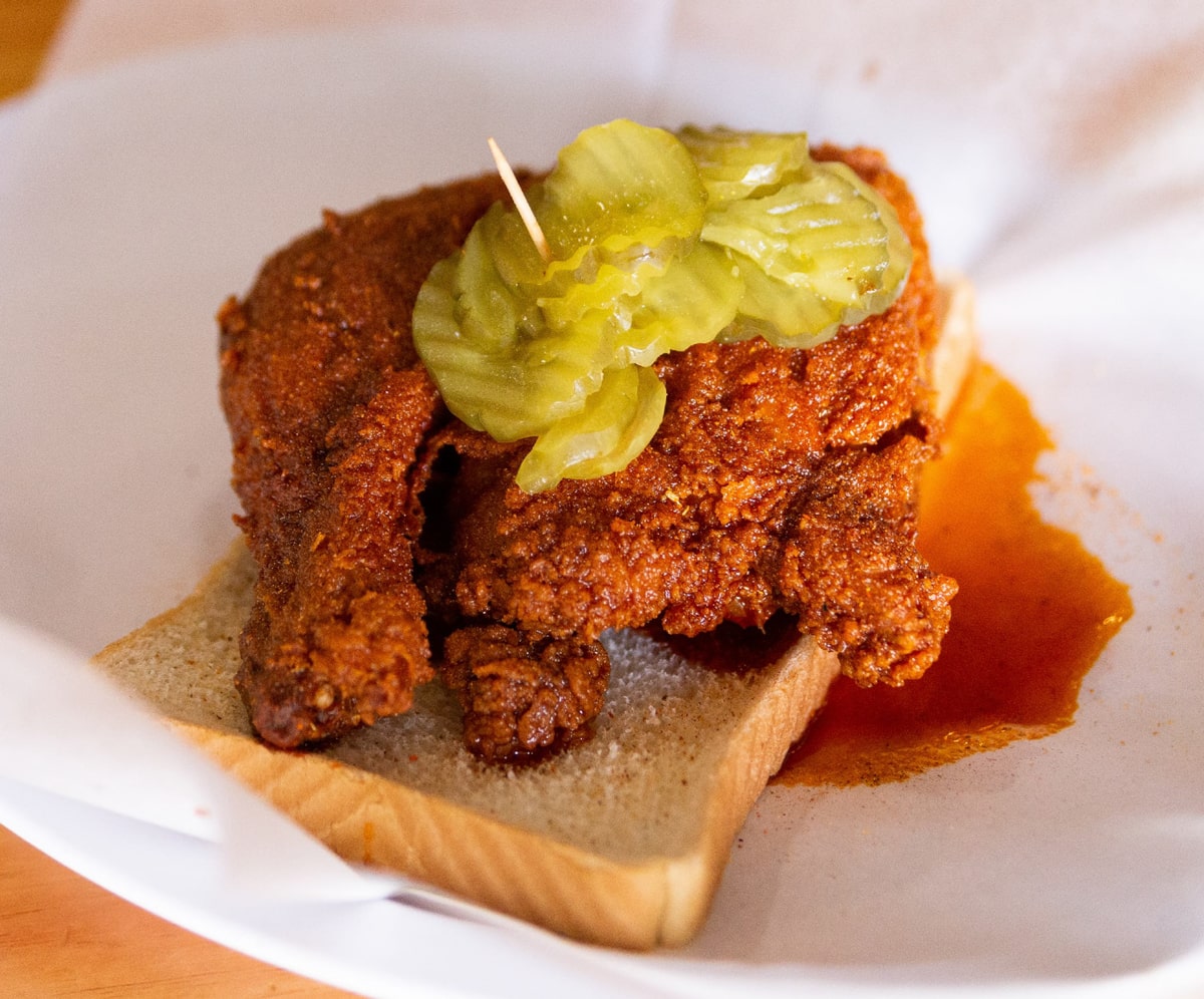 hot chicken on top of white bread with pickles at prince's hot chicken shack