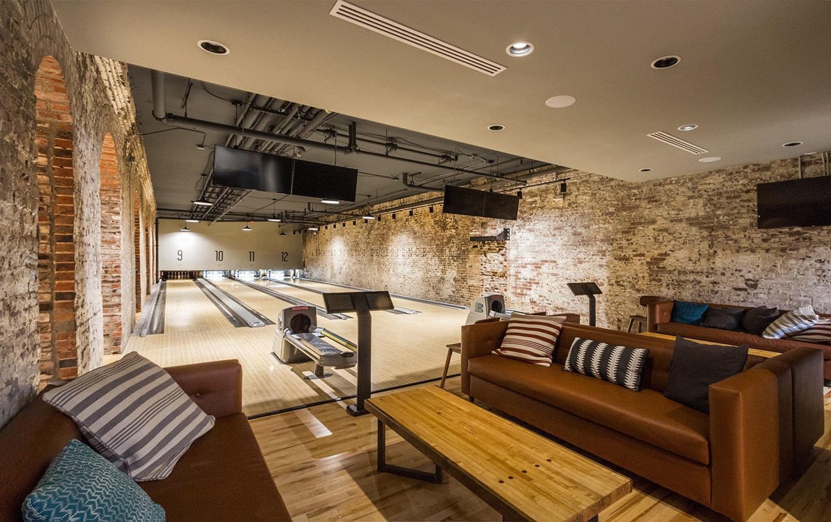 Bowling ally with leather couches and limewashed brick walls
