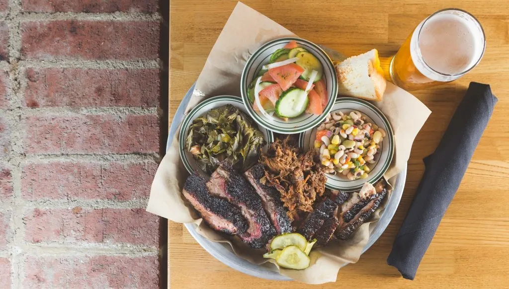 Top-down view of plate of bbq brisket and sides with a beer, from the Southern Craft BBQ restaurant in Bristol TN-VA.