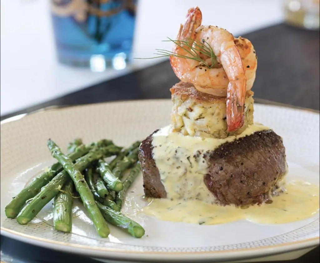 Dinner plate of steak, shrimp, crab cake, and asparagus. 