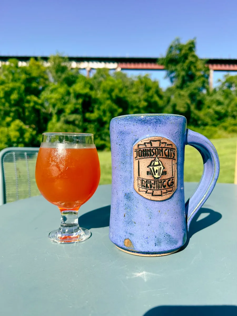 Pints of beer at Johnson City Brewing Company Boone's Creek location with railroad in the background