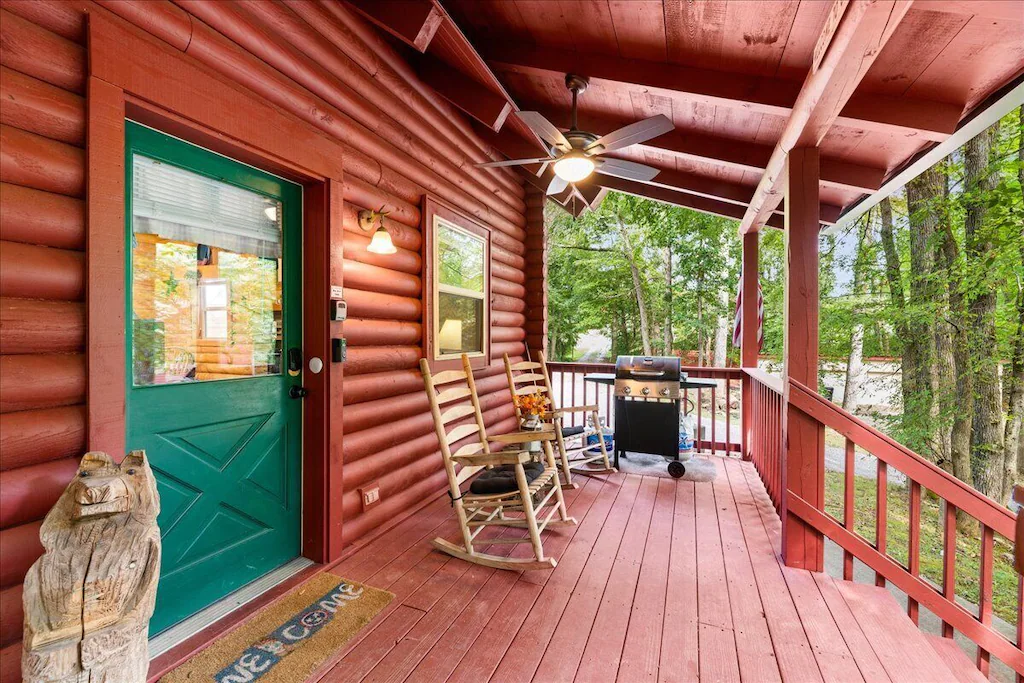 little joe cabin in knoxville tn with log cabin siding and green front door