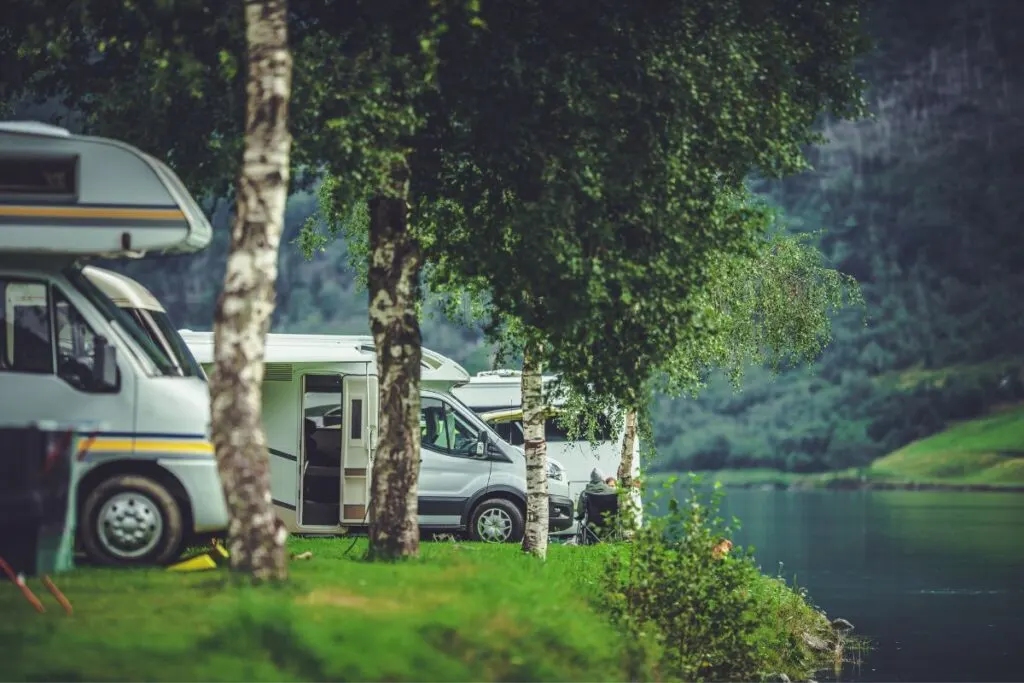 RVs parked along riverbank.