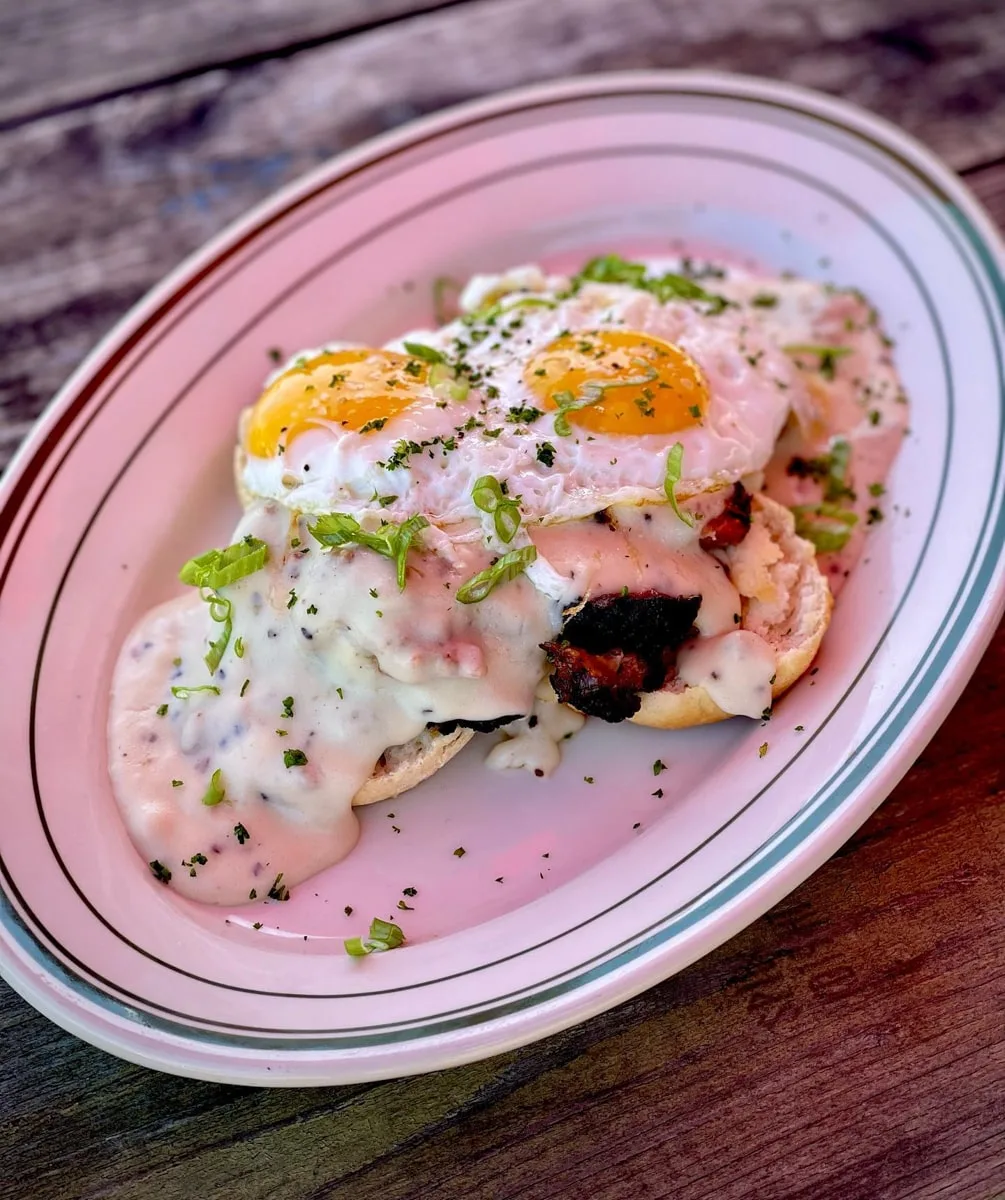 Biscuits and gravy topped with brisket, eggs, and green onions at southern craft in Johnson City