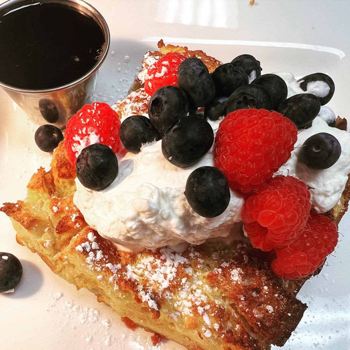 Cafe Lola French Toast topped with berries and whipped cream