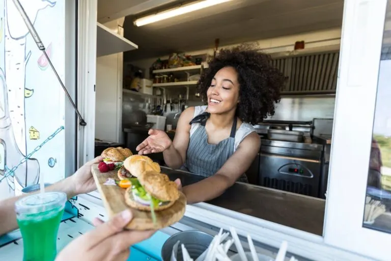 Woman selling sliders out of a food truck.