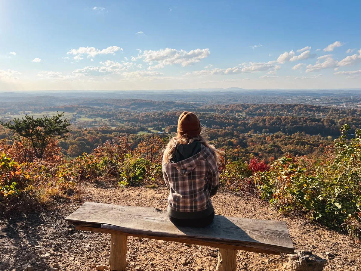 woman on buffalo mountain park overlooking johnson city tn in the fall with beautiful fall foliage