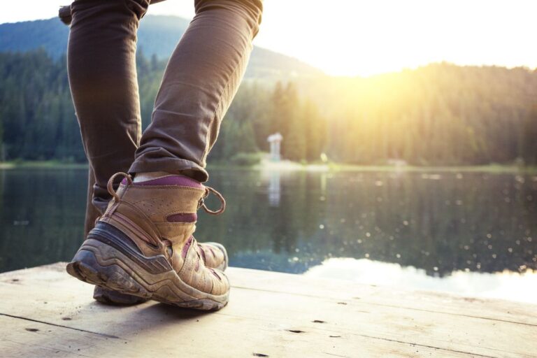 Person wearing hiking boots on a trail near Nashville overlooking pond