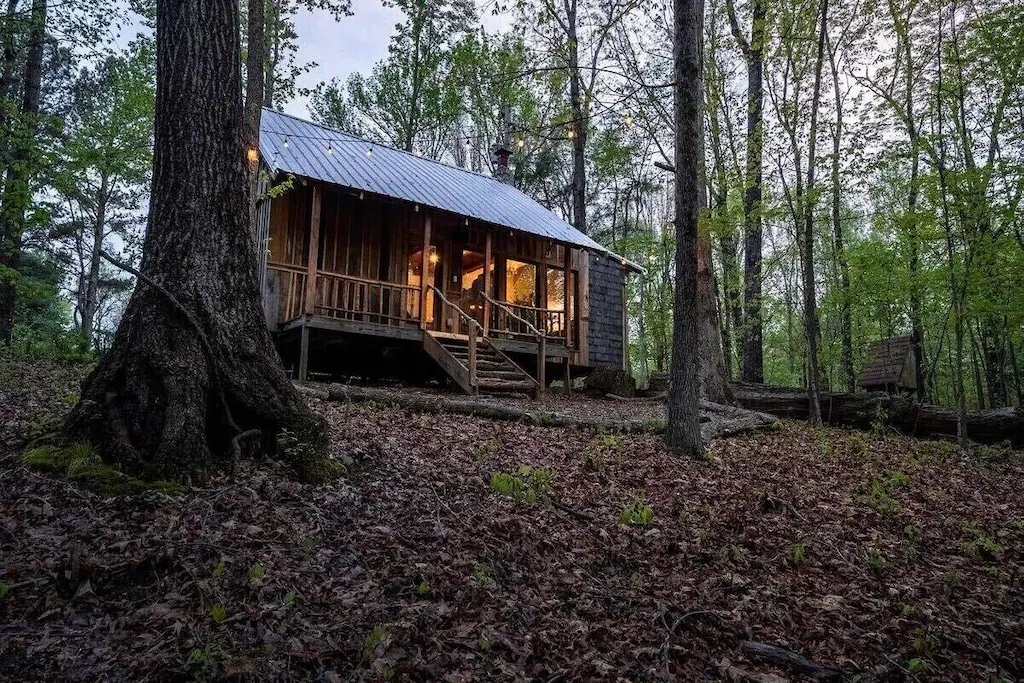 a cabin in the woods in nashville with log cabin siding and metal roof 