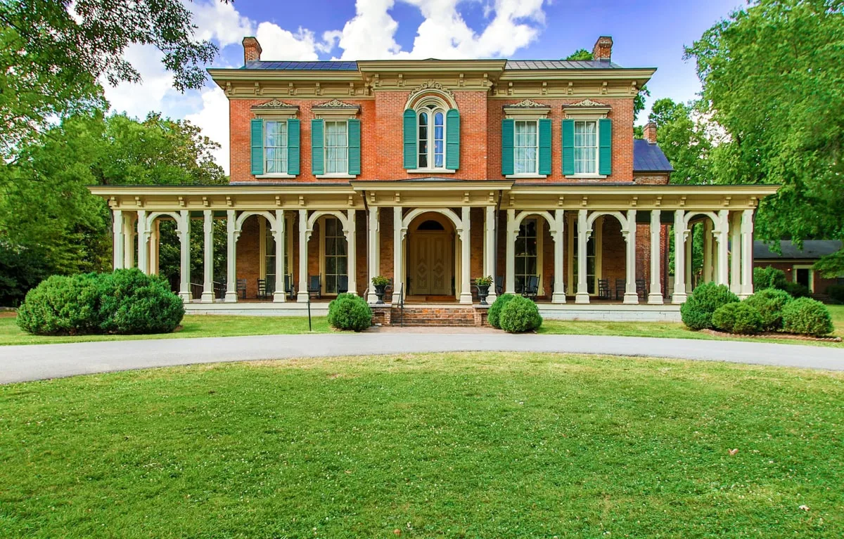 Oaklands mansion exterior with red brick and green shutters 