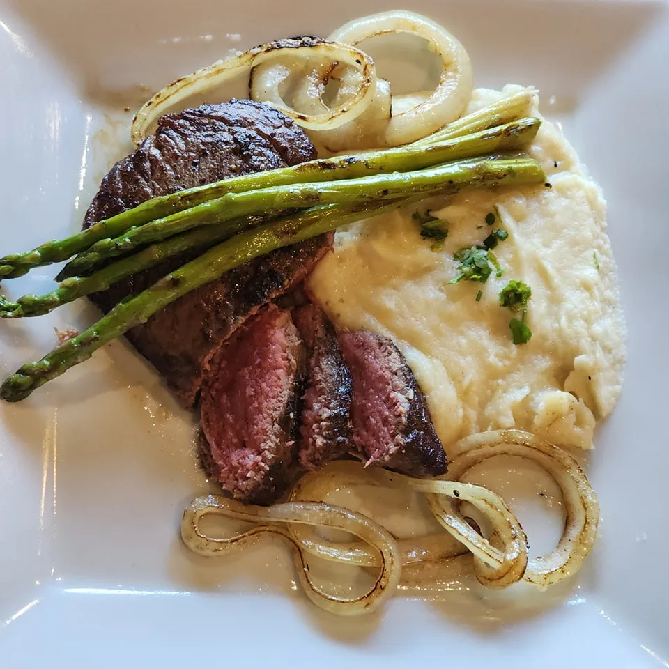 medium rare steak with grilled onions, asparagus, and mashed potatoes 