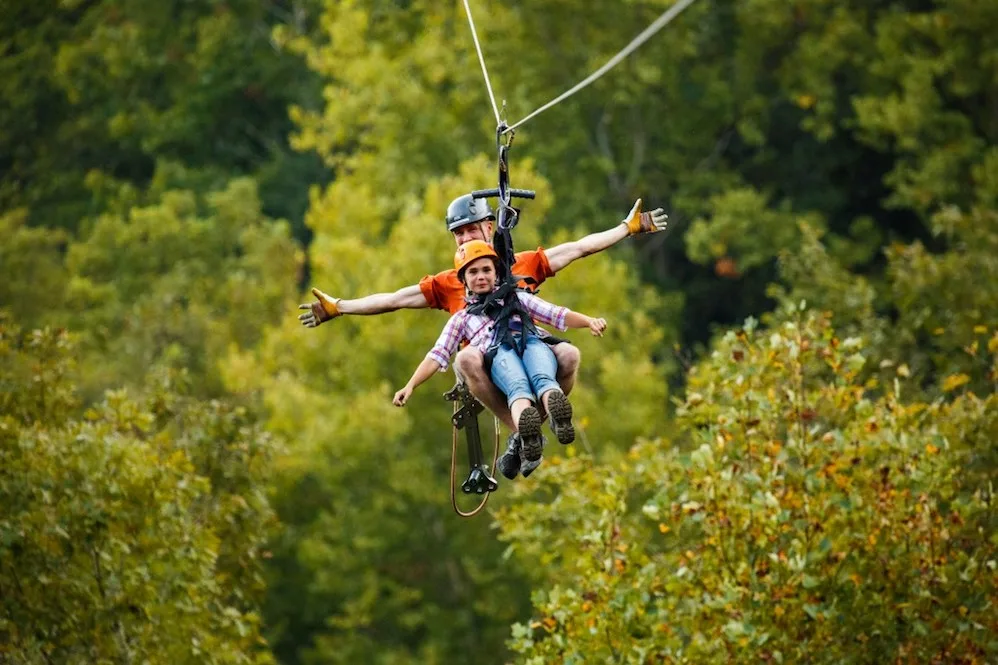 people ziplining above the smoky mountain trees in sevierville tn 