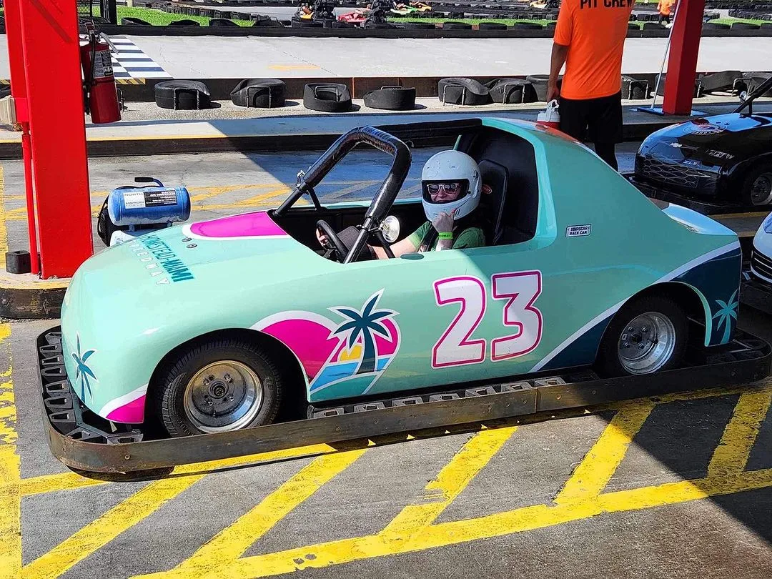 girl inside a racecar with helmet at the NASCAR SpeedPark in Sevierville TN