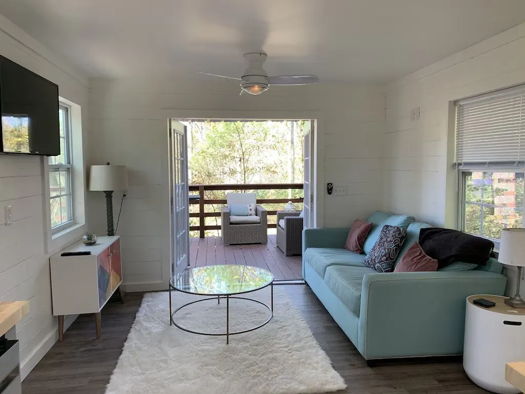 a cabin near nashville tn with couch and open patio doors overlooking the woods 