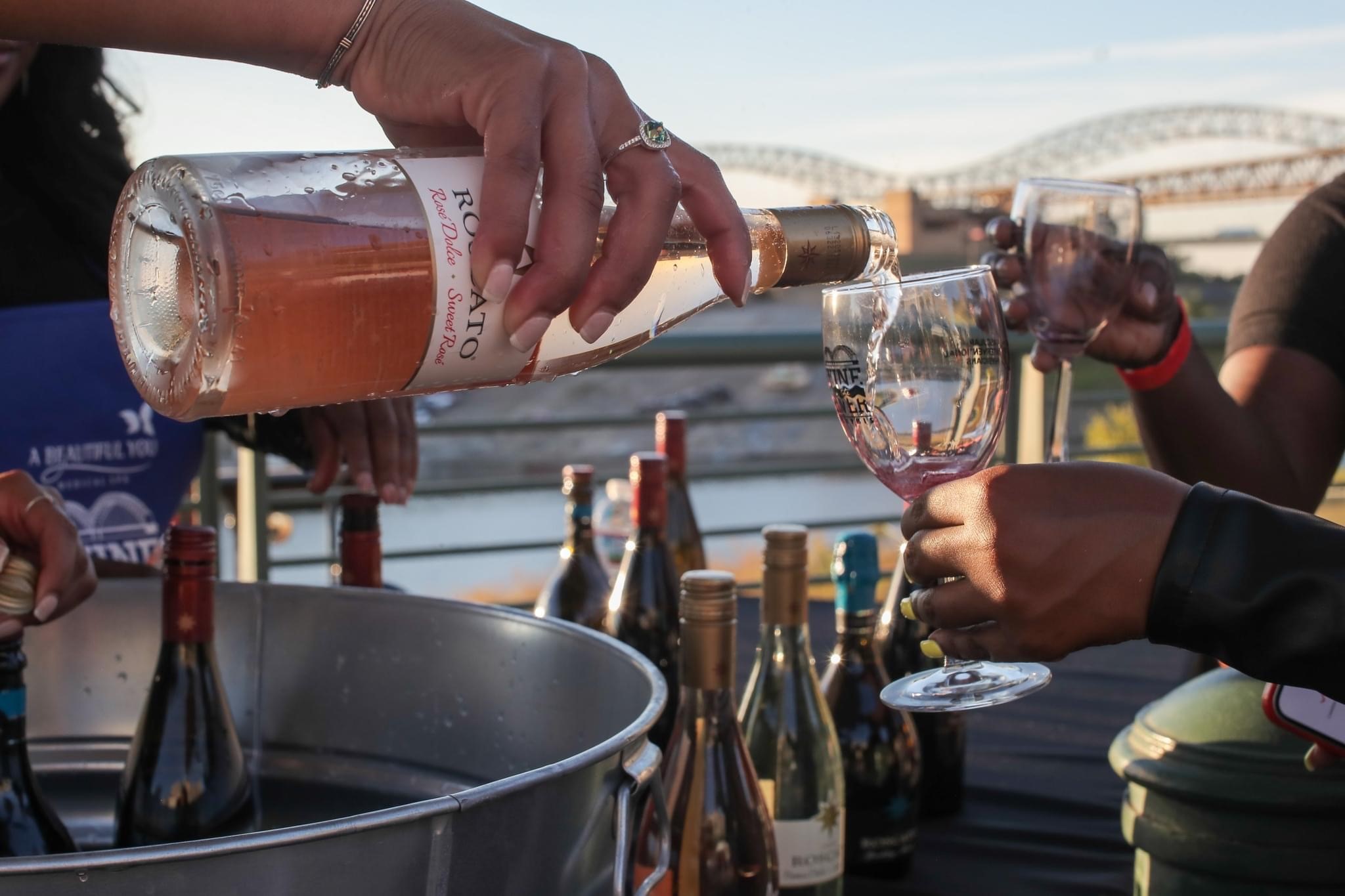 woman pouring wine into a wine glass at wine on the river event in downtown nashville tn 