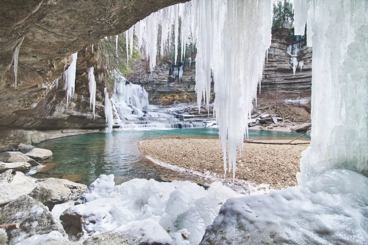 winter at cummins falls view behind the waterfall with frozen ice cycles and water