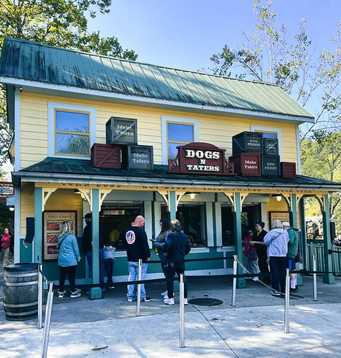 people waiting in line at dogs n taters concession stand in dollywood theme park 