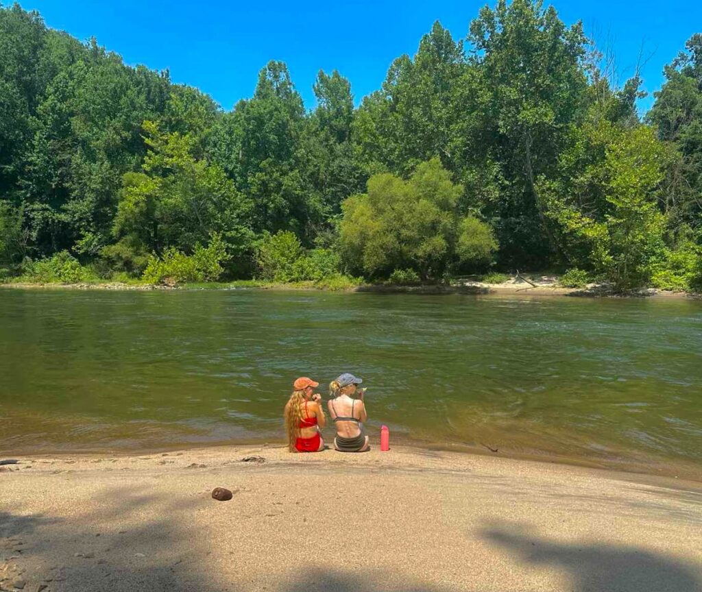 Laurin and Bri sitting on the banks of the river in East Tennessee