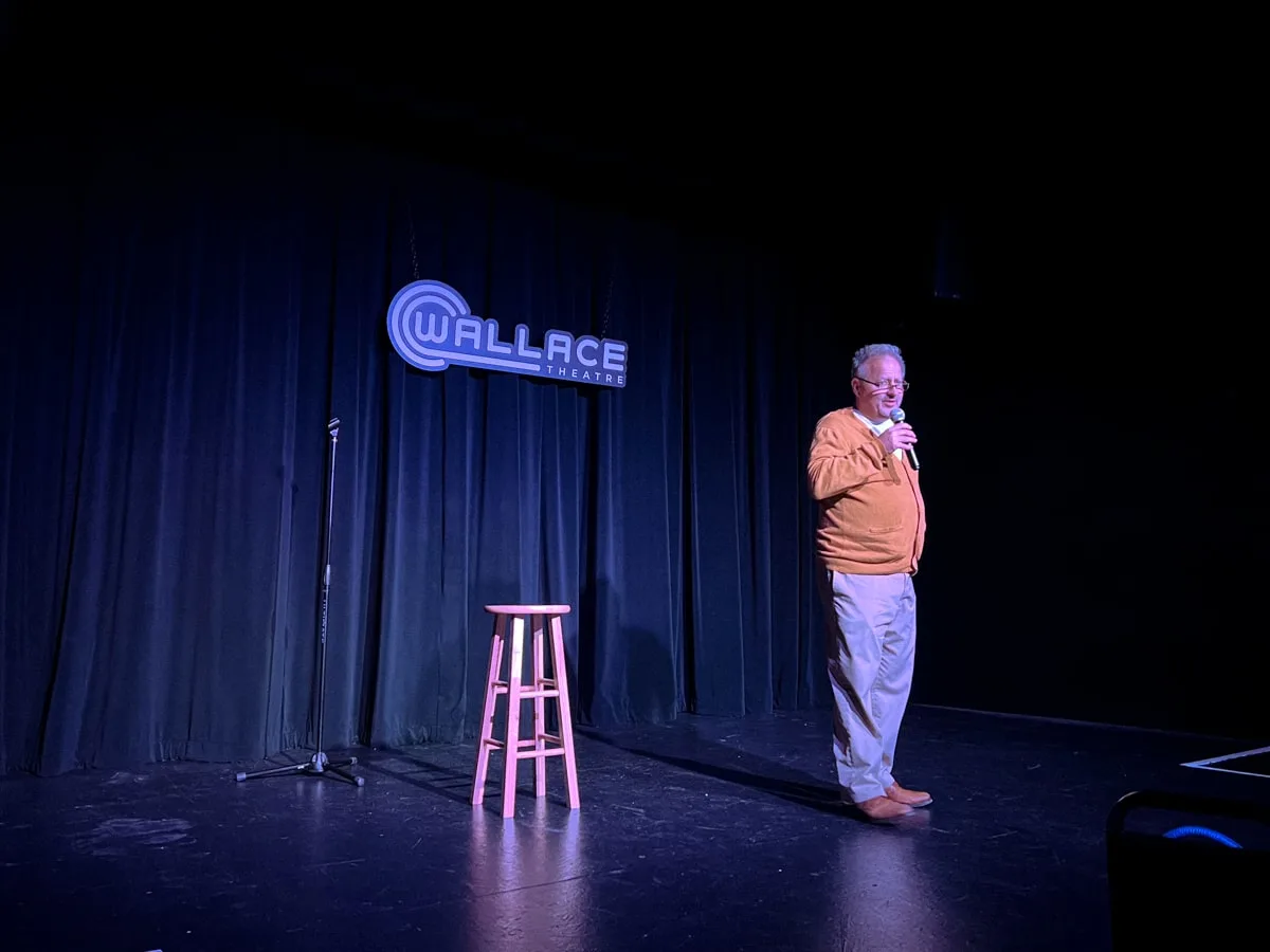 man performing stand up comedy on the wallace theatre stage in downtown johnson city tn 