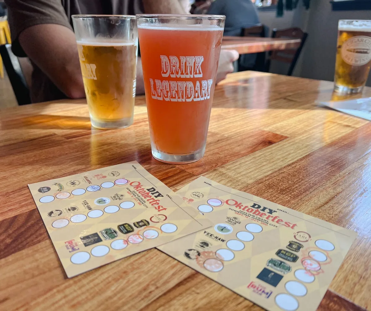 people drinking beers in downtown johnson city for the diy oktoberfest with oktoberfest check off cards